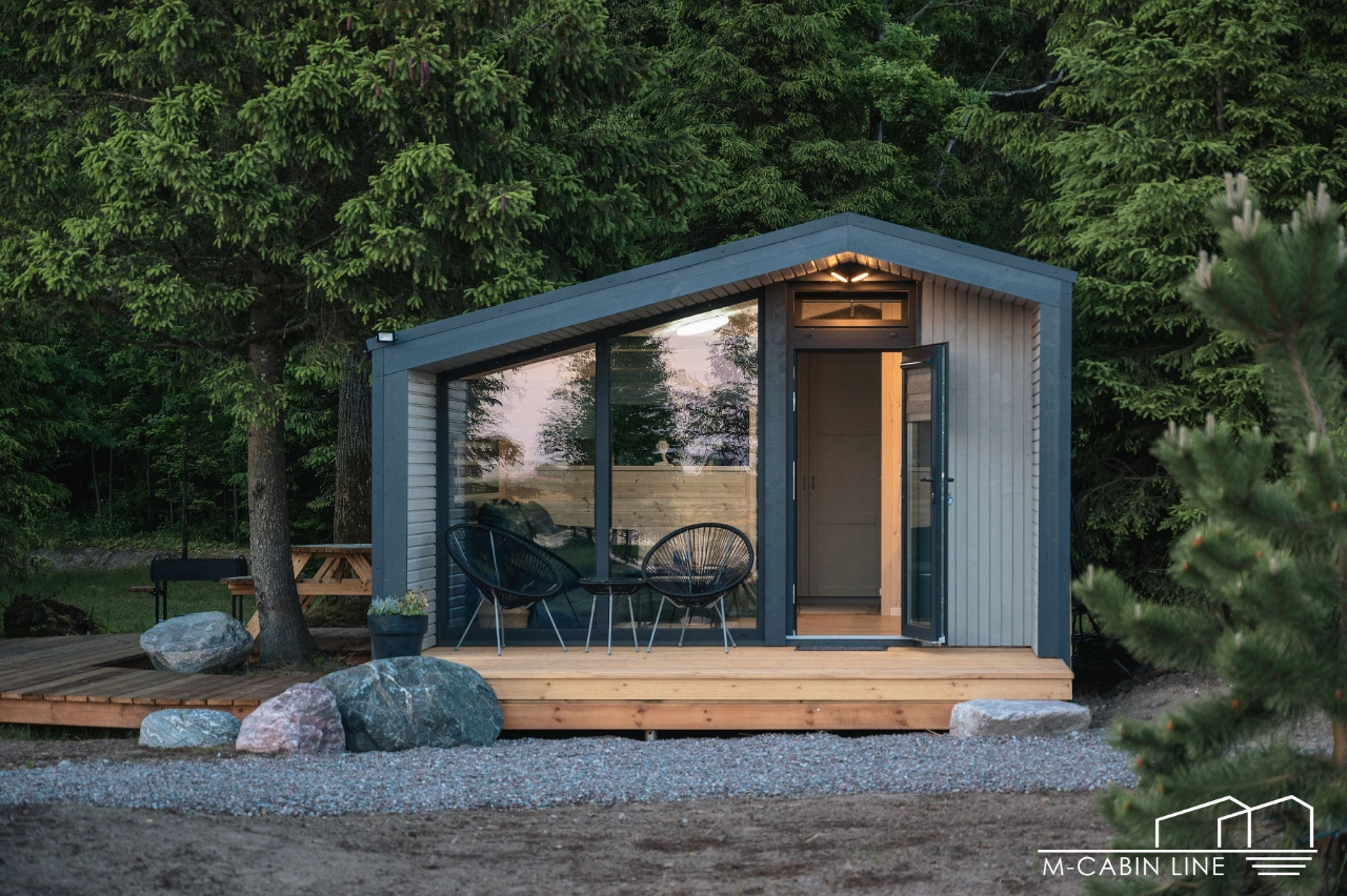 M28 von M-Cabin Line: Modul mit grau-blauer Metallfassade, Glasfront und überdachtem Sitzplatz